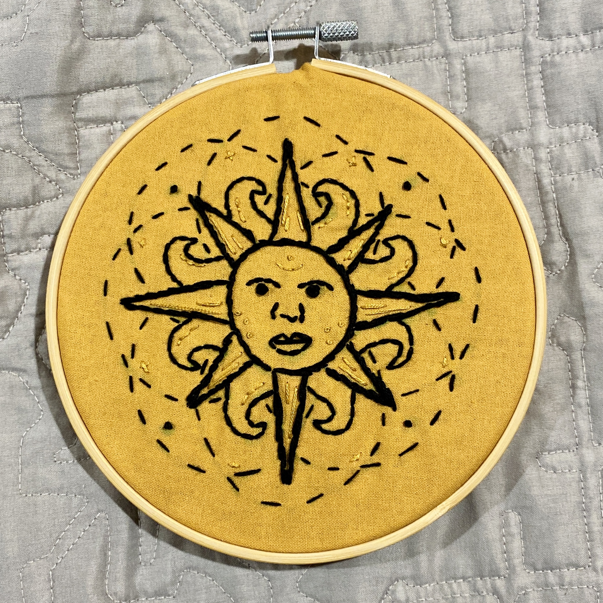 Embroidery of an anthropomorphic sun.